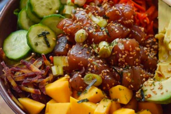 An inspired bowl of Hawaiian food on a wooden table at a luau.