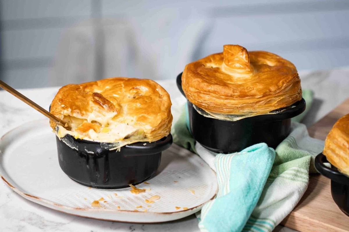 Chicken pot pie in a black pot on a counter, perfect for Thanksgiving or a potluck.