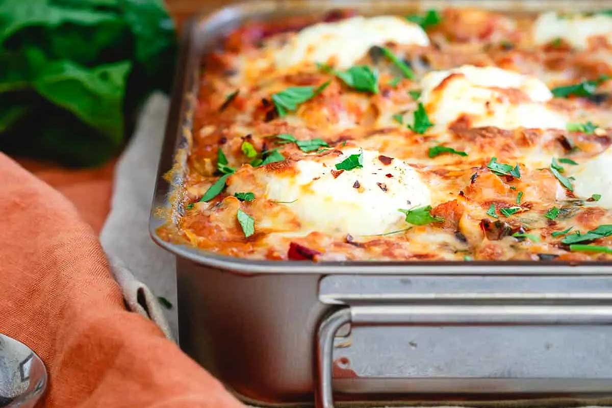 A casserole dish with eggs and spinach on it.
