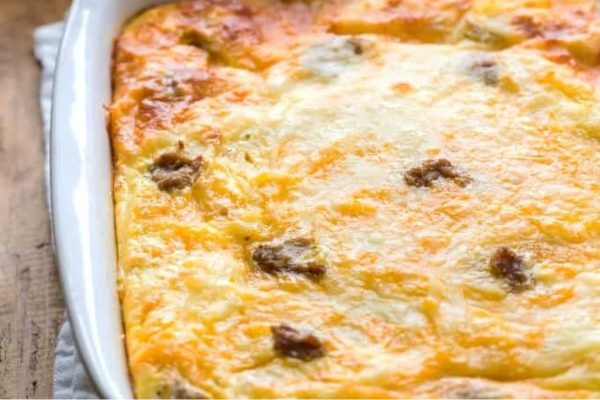 Cheesy breakfast casserole in a white dish.