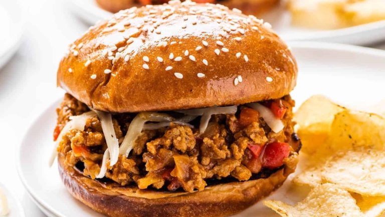 A plate of ground turkey burgers and chips on a white plate.
