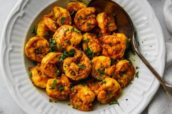 Fried shrimp on a white plate with a spoon.