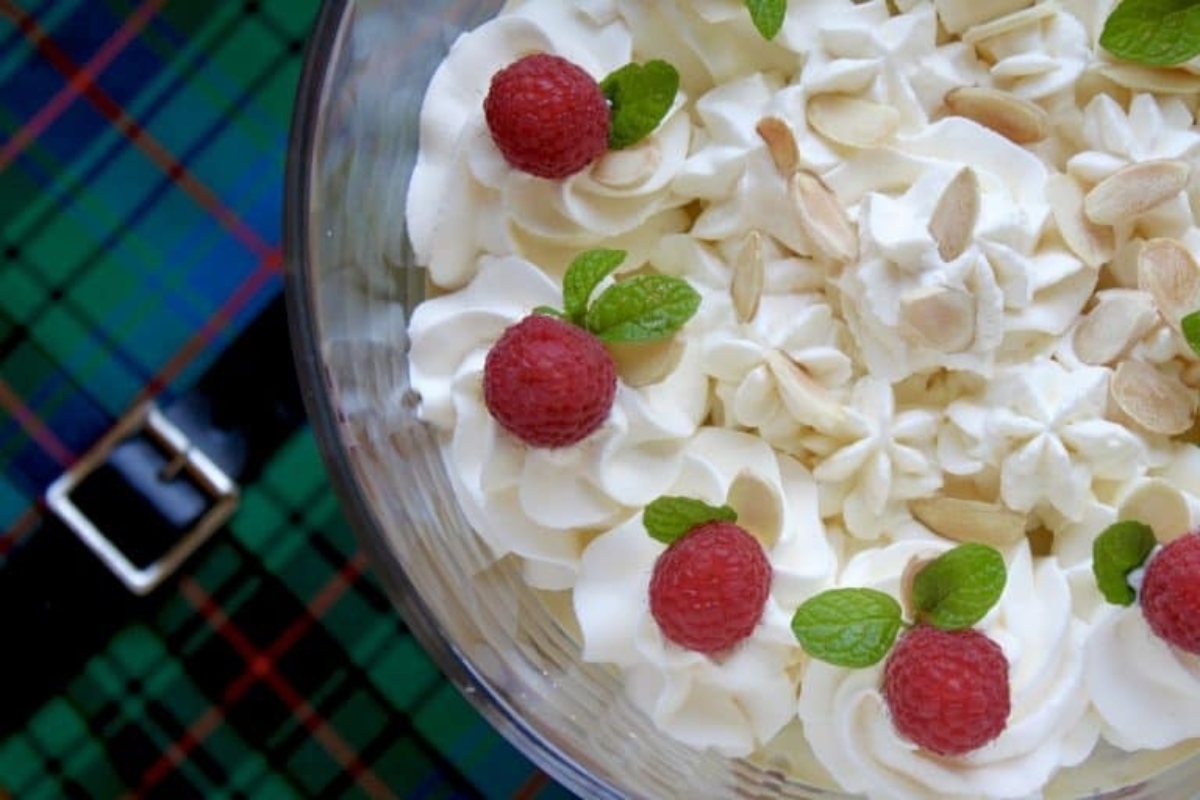 A glass bowl filled with whipped cream, raspberries, and Christmas spirit.