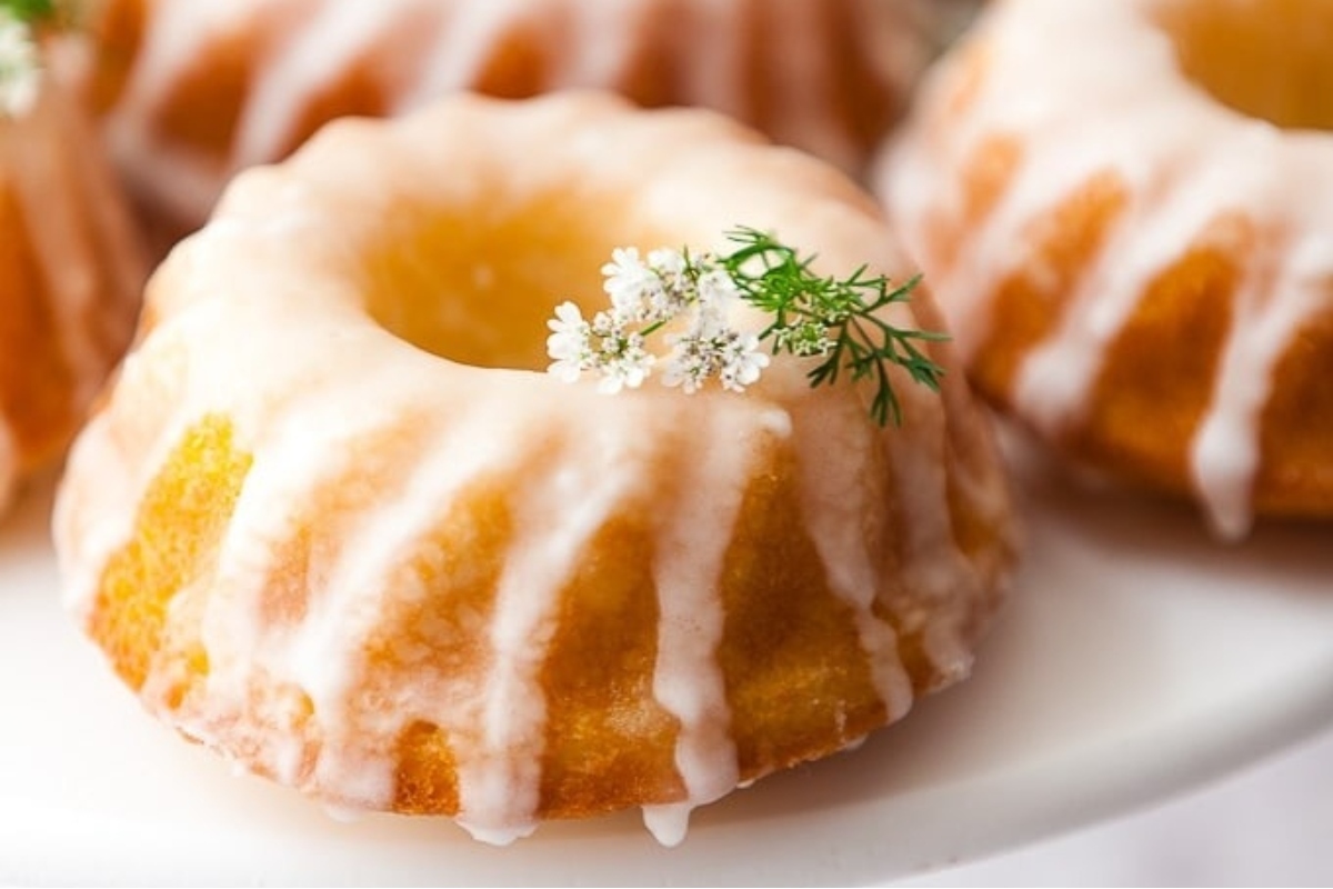 Mini bundt cakes with a dill-infused icing arranged on a plate.