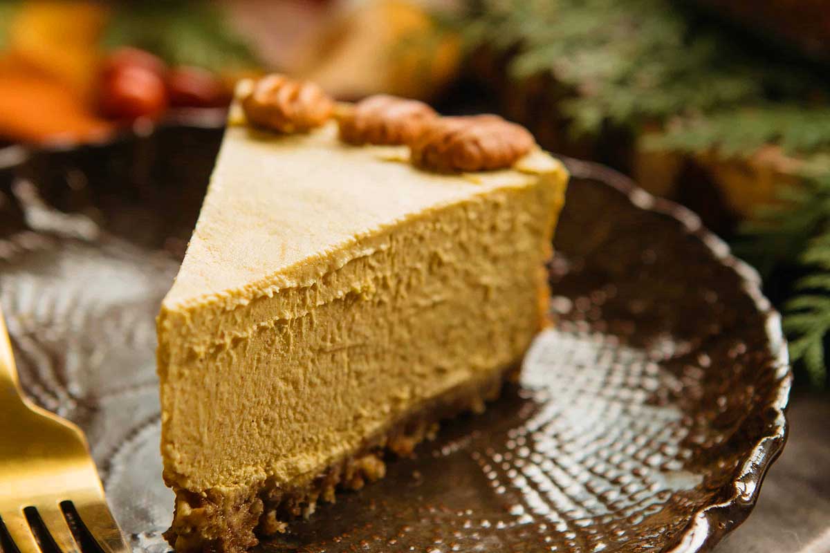 A slice of vegan pumpkin cheesecake on a plate.