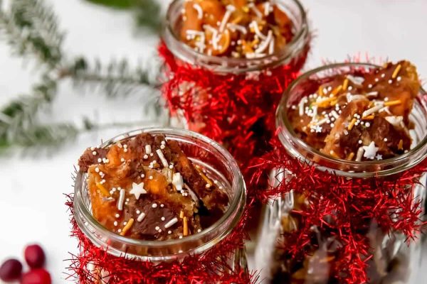 Three jars filled with chocolate and cranberries.