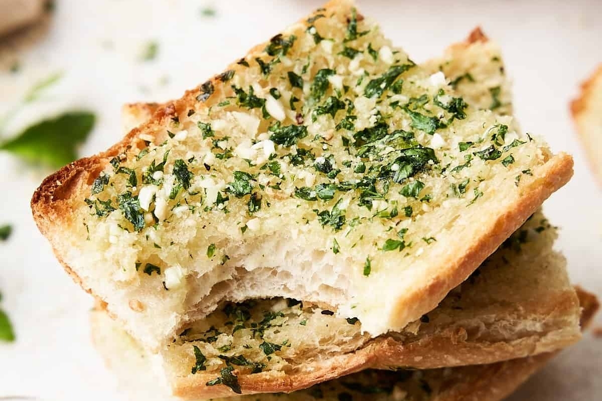 An Italian side dish of a stack of garlic bread with parsley on top.