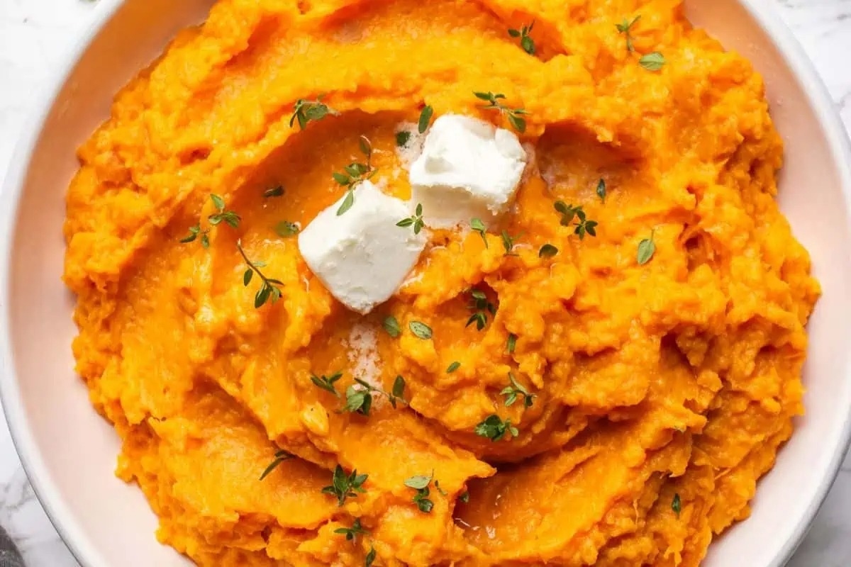 Sweet potato mashed potatoes in a white bowl.