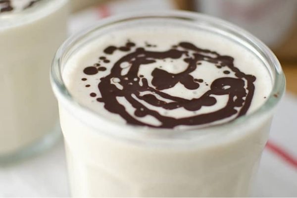 A delectable milkshake topped with luscious chocolate and creamy icing.