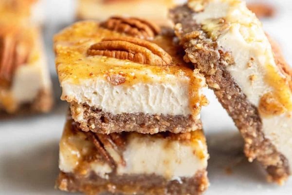 Pecan cheesecake bars stacked on top of each other.
