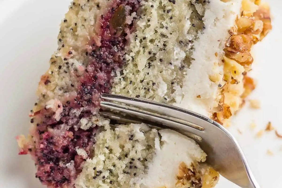 A slice of blackberry poppy seed cake on a plate with a fork.