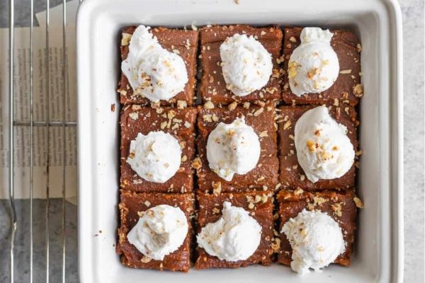 A baking dish filled with brownies and whipped cream.