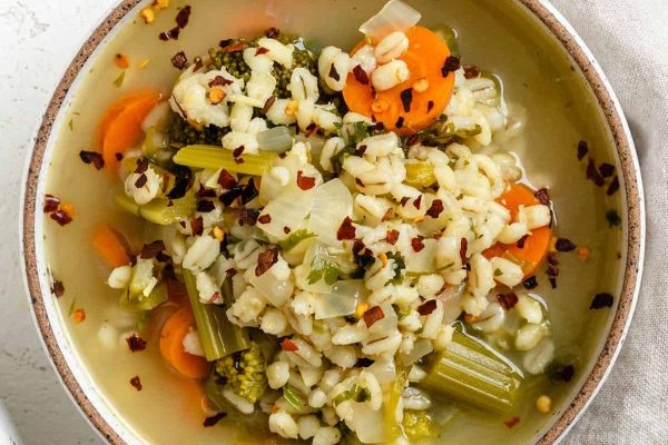 A bowl of soup with broccoli and carrots.