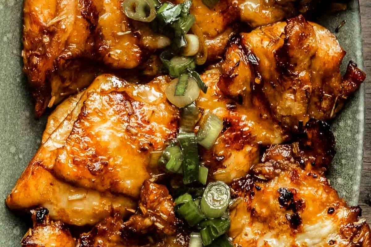 A flavorful plate with grilled chicken and green onions, perfect as a main dish for a dinner party.