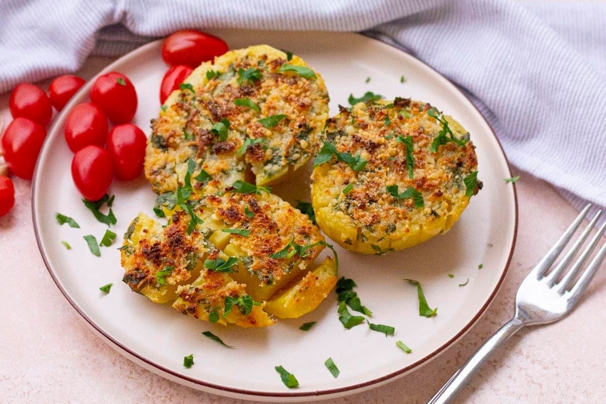 Stuffed peppers on a plate with tomatoes and herbs.