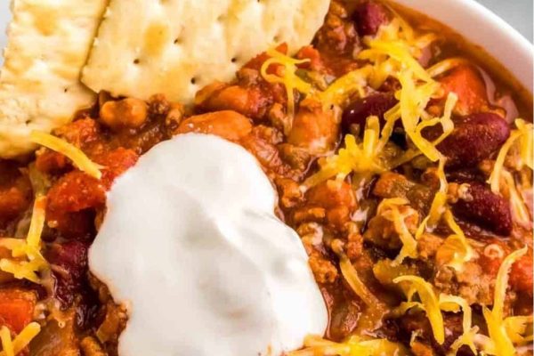 Budget-friendly chili bowl with crackers and sour cream.