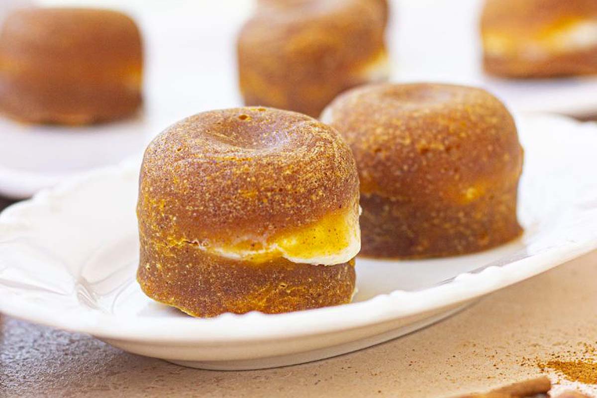 A white plate with a few cinnamon donuts on it, perfect for an Instant Pot Thanksgiving dessert.