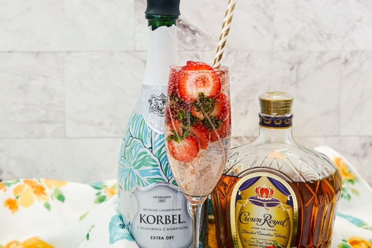 A glass of champagne with strawberries and a bottle of champagne.

Keywords: Champagne
