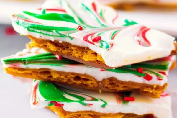 A stack of christmas candy bars on a white plate.