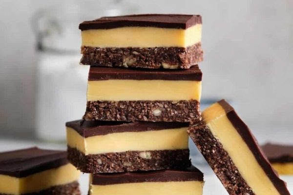 A stack of chocolate and peanut butter bars on a white plate.