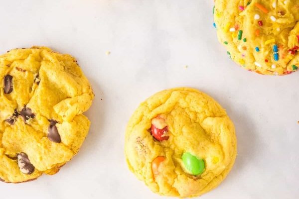 A group of yellow cookies on a white surface.