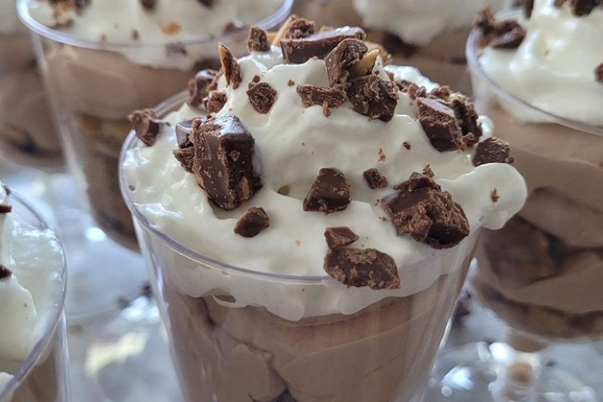 A group of Christmas trifles filled with chocolate pudding and whipped cream.