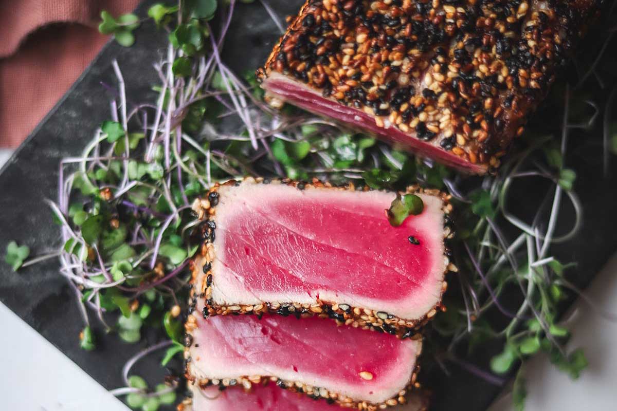 A piece of meat with seeds on top.