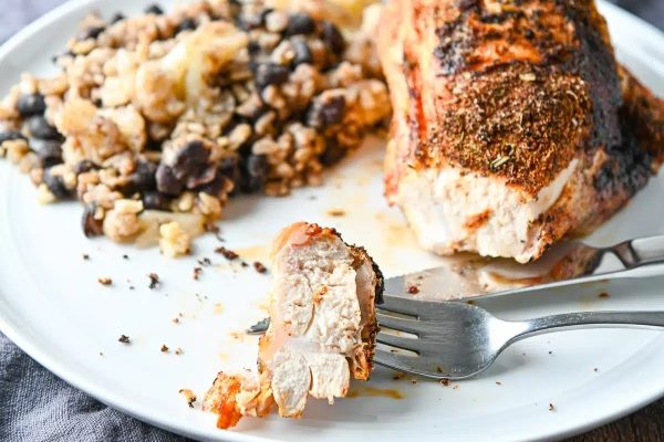 A plate with bone-in chicken and rice on it.