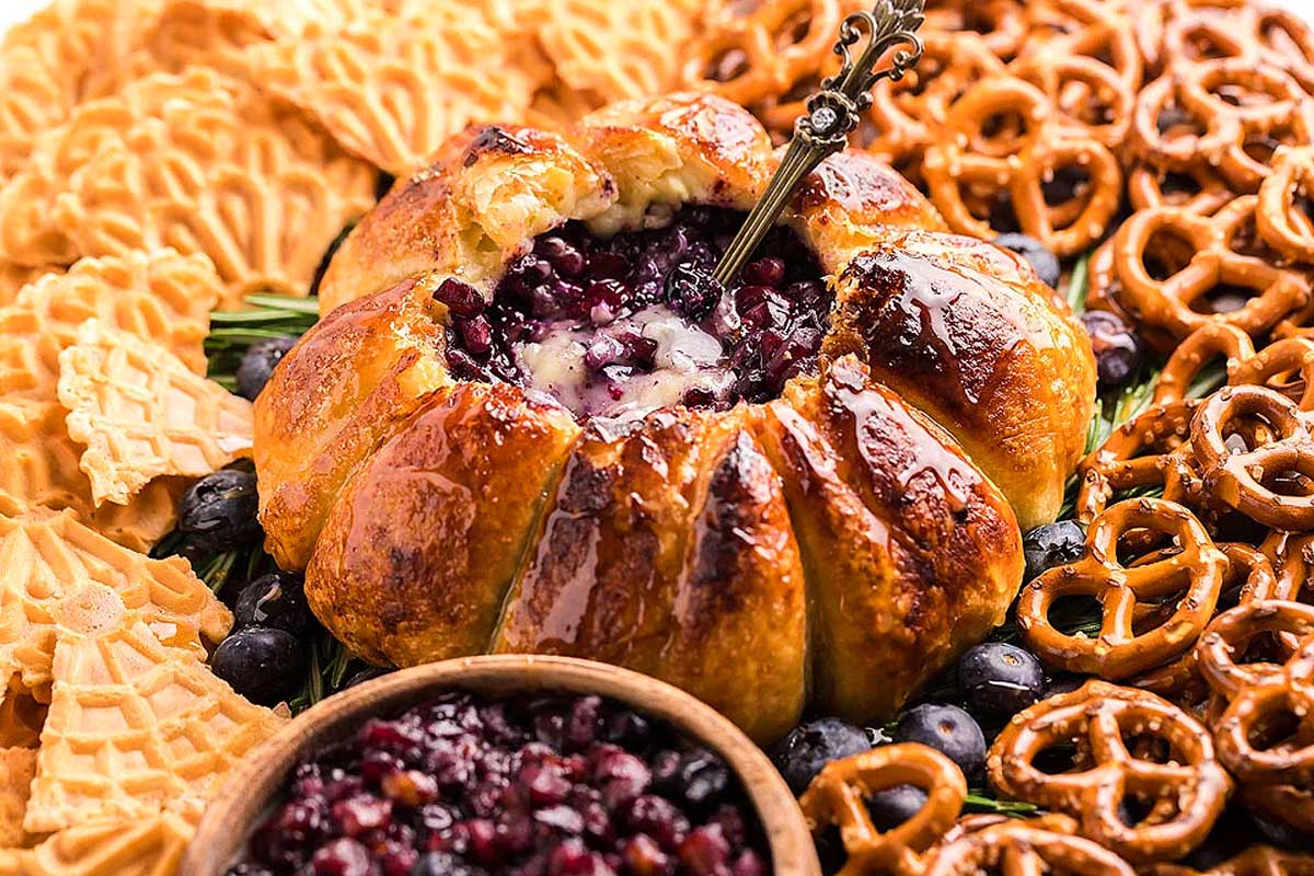 A delectable blueberry cheesecake with a unique twist, featuring the perfect combination of crunchy pretzels and pretzel sticks incorporated into its fluffy texture.