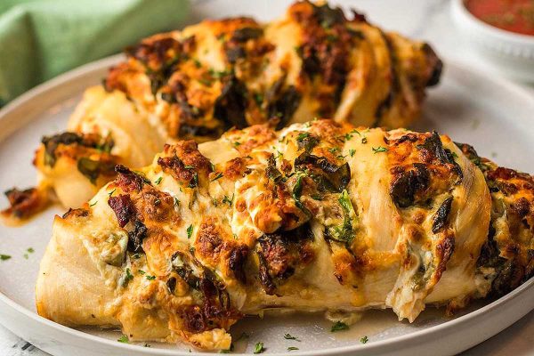 Two stuffed chicken breasts on a plate.