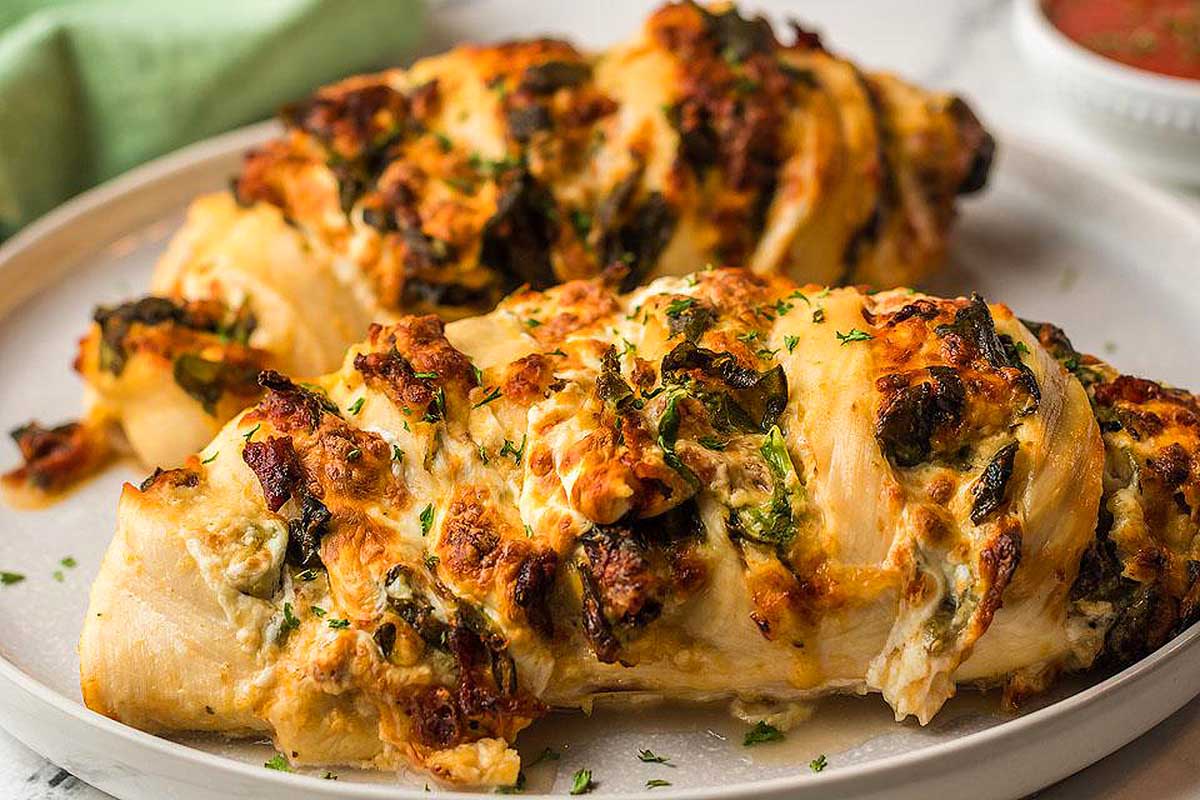 Two stuffed chicken breasts on a plate.