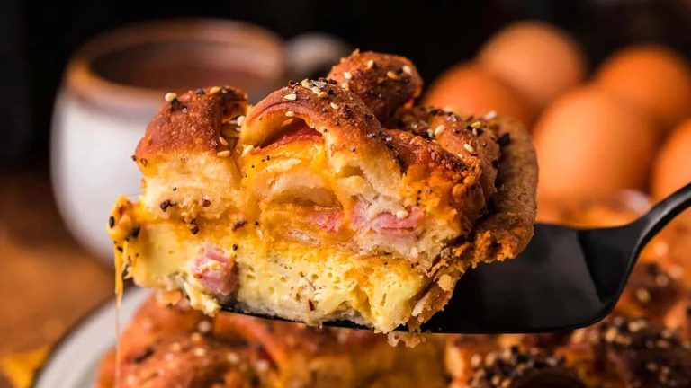 A delectable brunch recipe featuring a fork holding a flavorful ham and cheese bread.