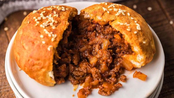 A sloppy joe with deliciously seasoned ground meat on a plate.
