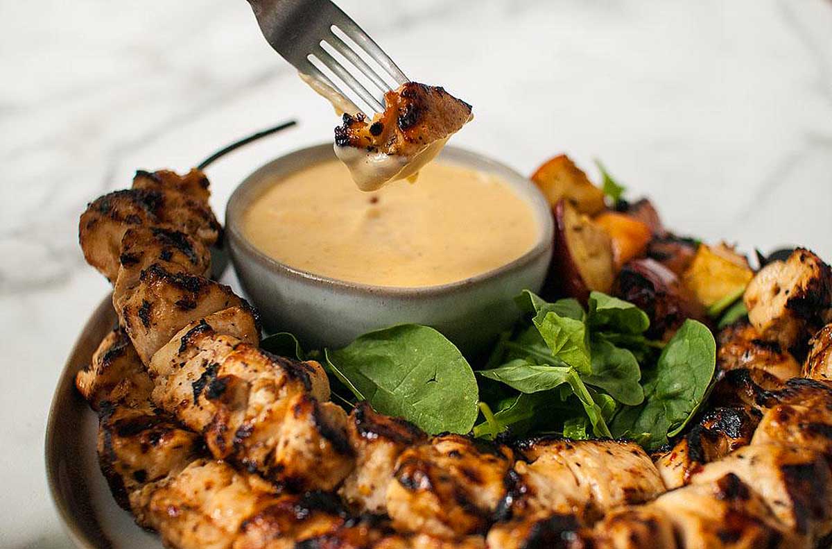 Grilled chicken skewers arranged on a plate with a fork.