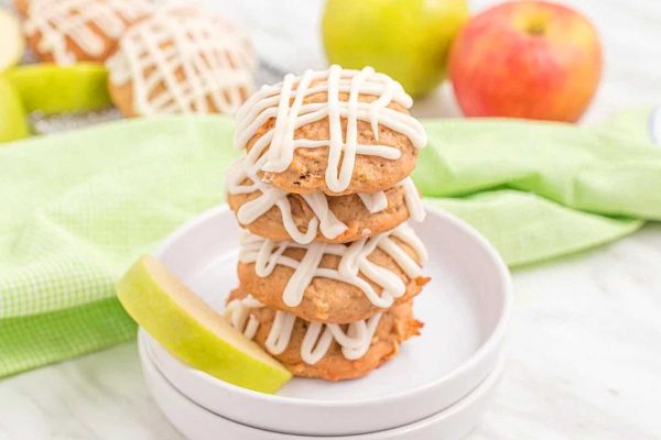 A stack of apple cookies with icing on top.