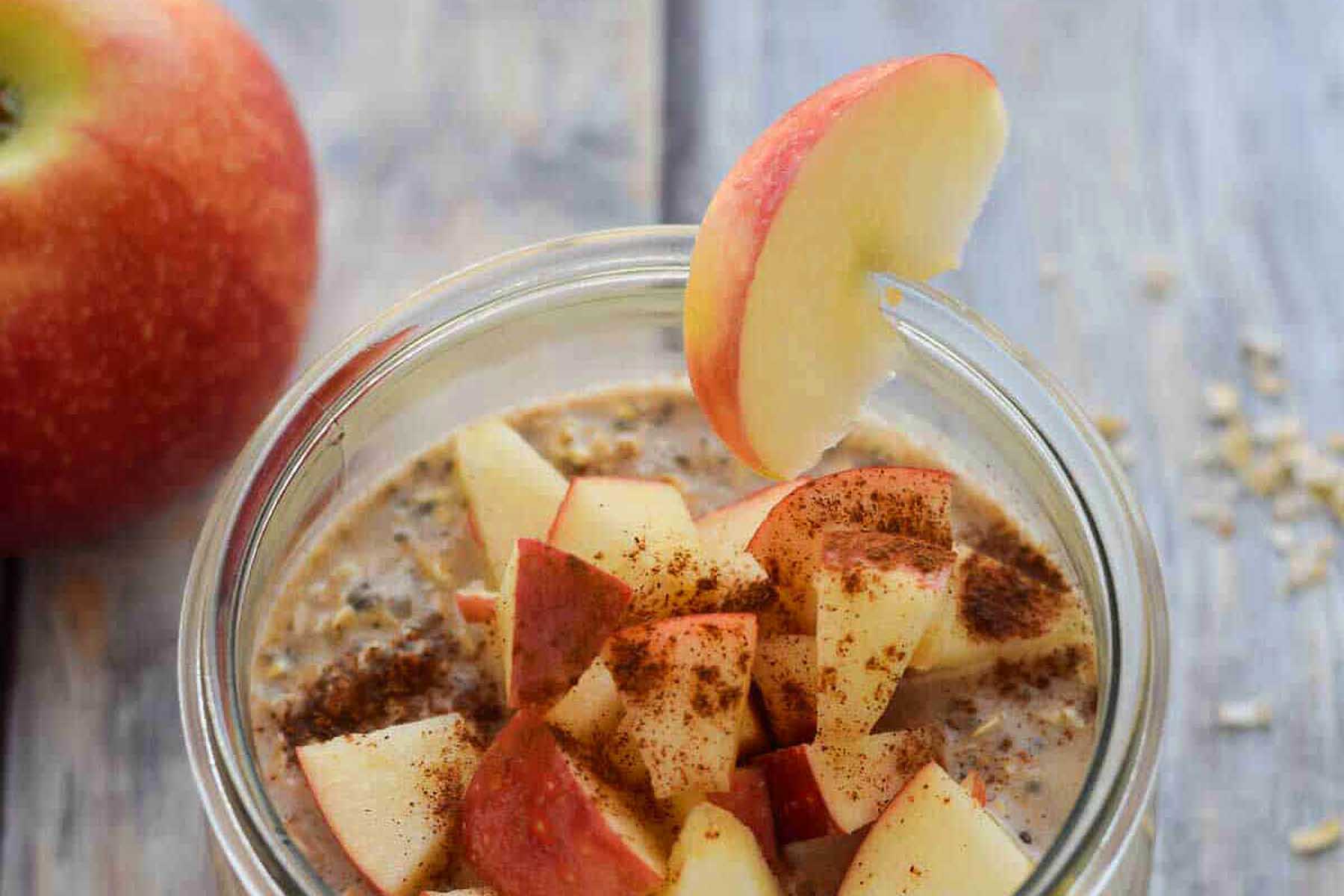 A jar of oatmeal with apples and cinnamon.