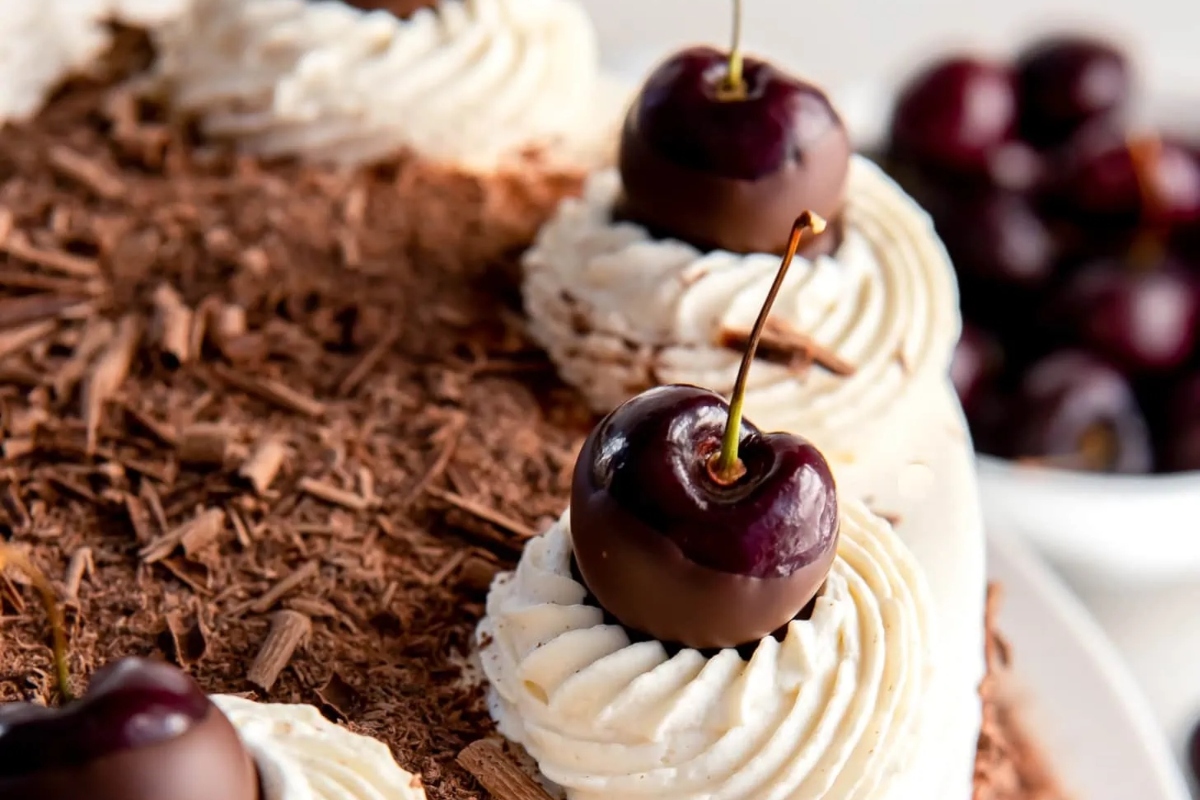 A German chocolate cake with cherries on top.