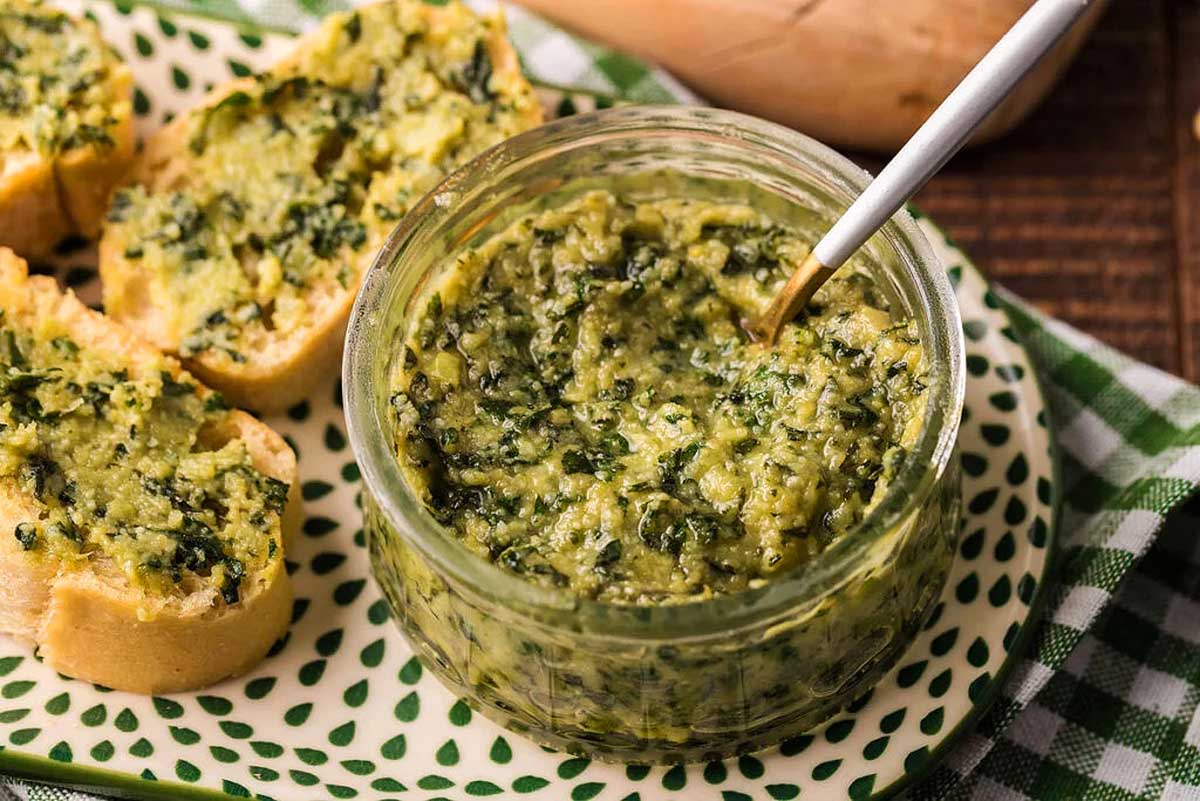 A plate with bread garnished with a jar of pesto, a popular sauce used in various recipes.