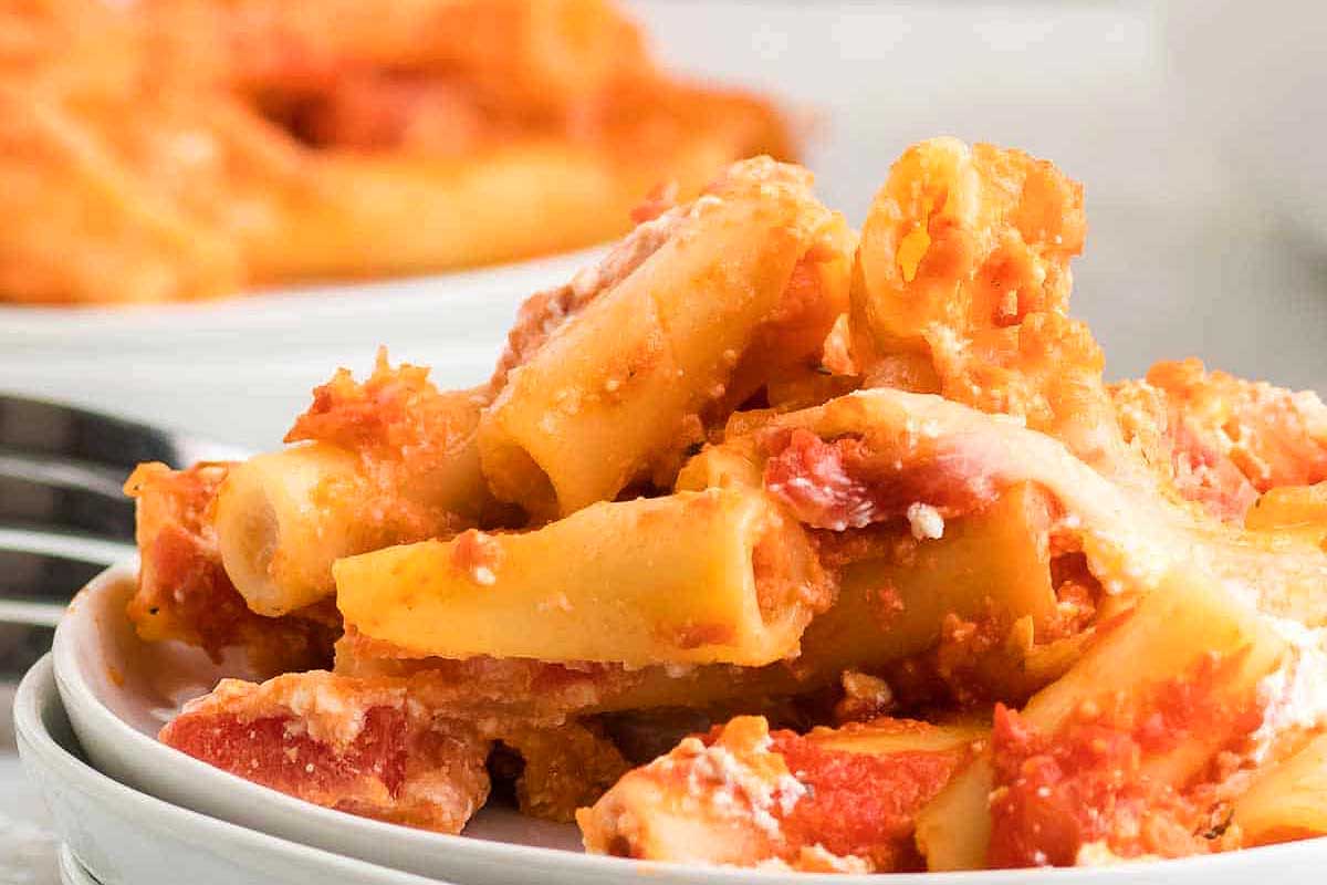 A bowl of pasta with tomato sauce and a fork.