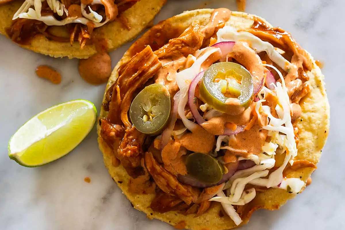 Mexican pulled pork tacos on a marble countertop.