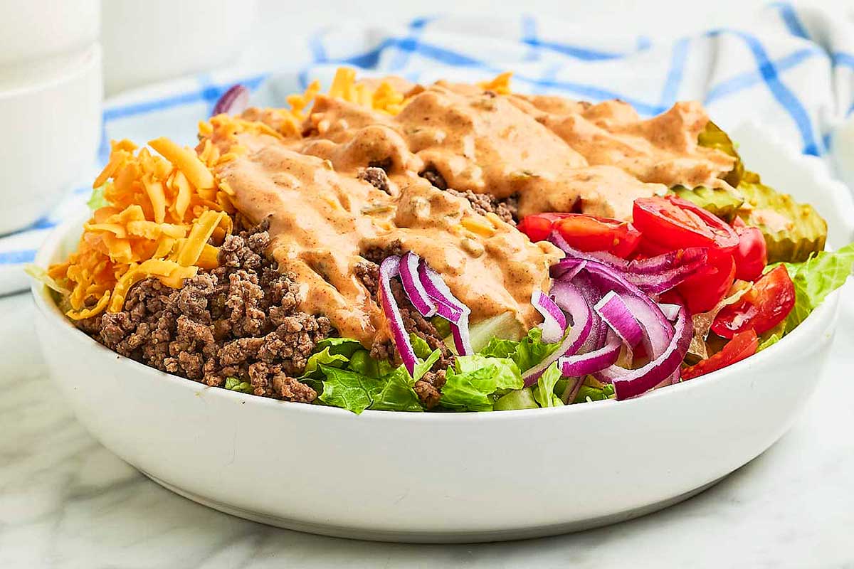 A white bowl with a salad in it.