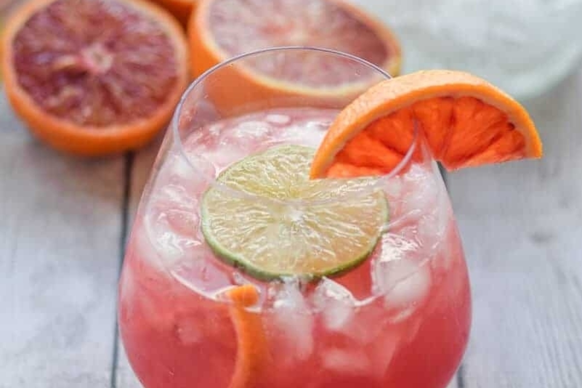 Blood orange margarita with lime and orange slices, perfect for Thanksgiving cocktails.