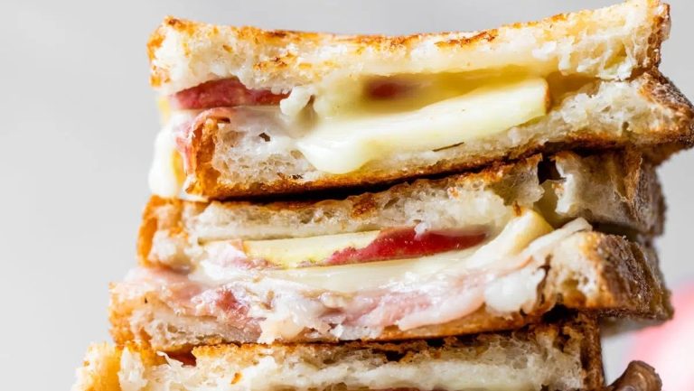 A stack of grilled cheese sandwiches with Brie and ham.