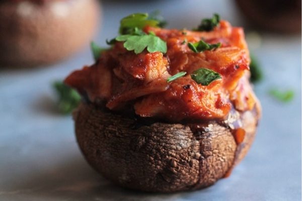 Stuffed mushrooms topped with meat and herbs.