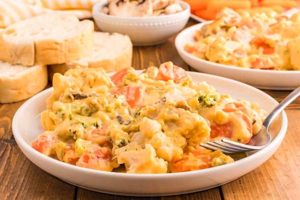 A bowl of chicken and cauliflower casserole on a wooden table.