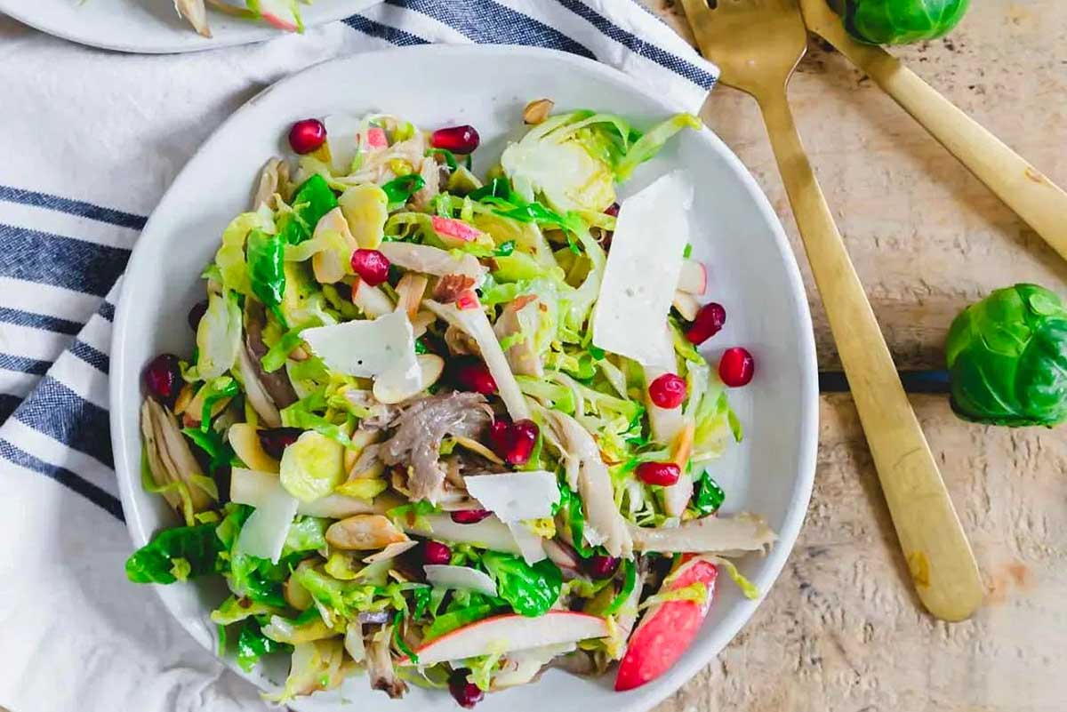 A plate of brussels sprouts, chicken and pomegranate salad.