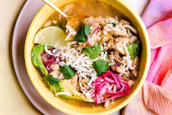 A yellow bowl filled with chicken and rice soup.