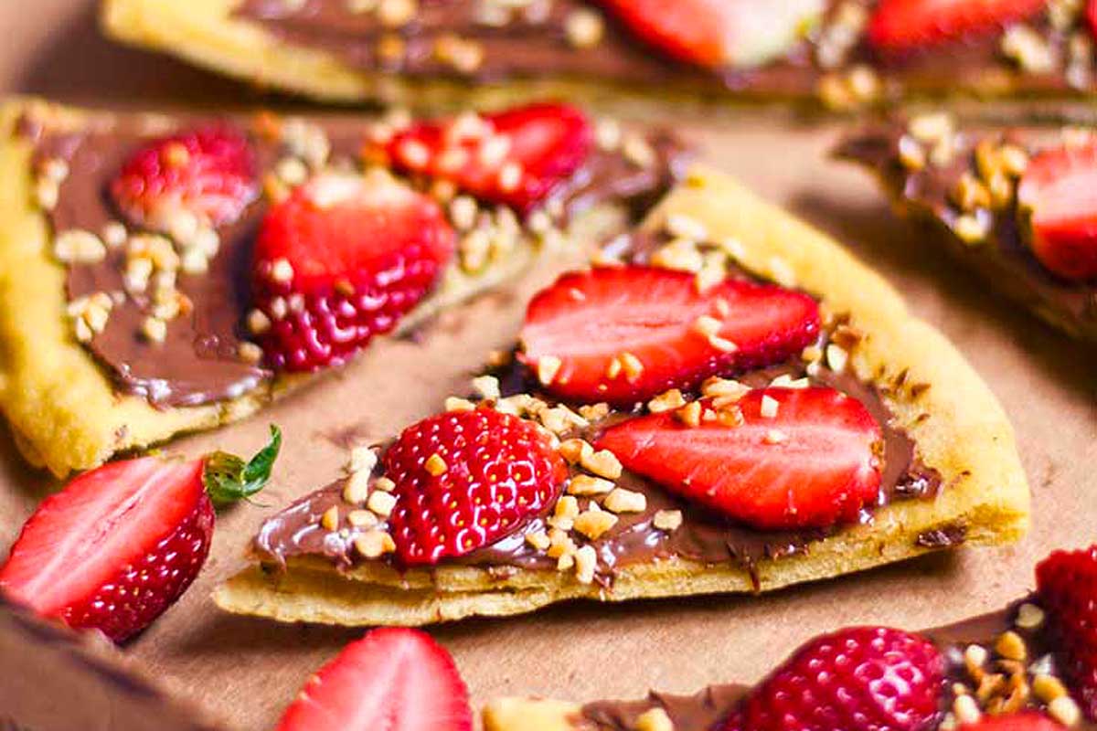 A slice of chocolate and strawberry pizza on a baking sheet.