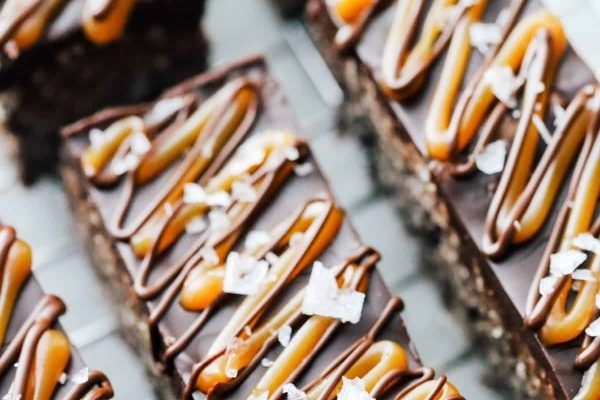 A stack of chocolate bars with caramel and coconut on top.