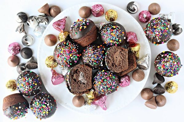 Chocolate cupcakes with sprinkles on a plate.